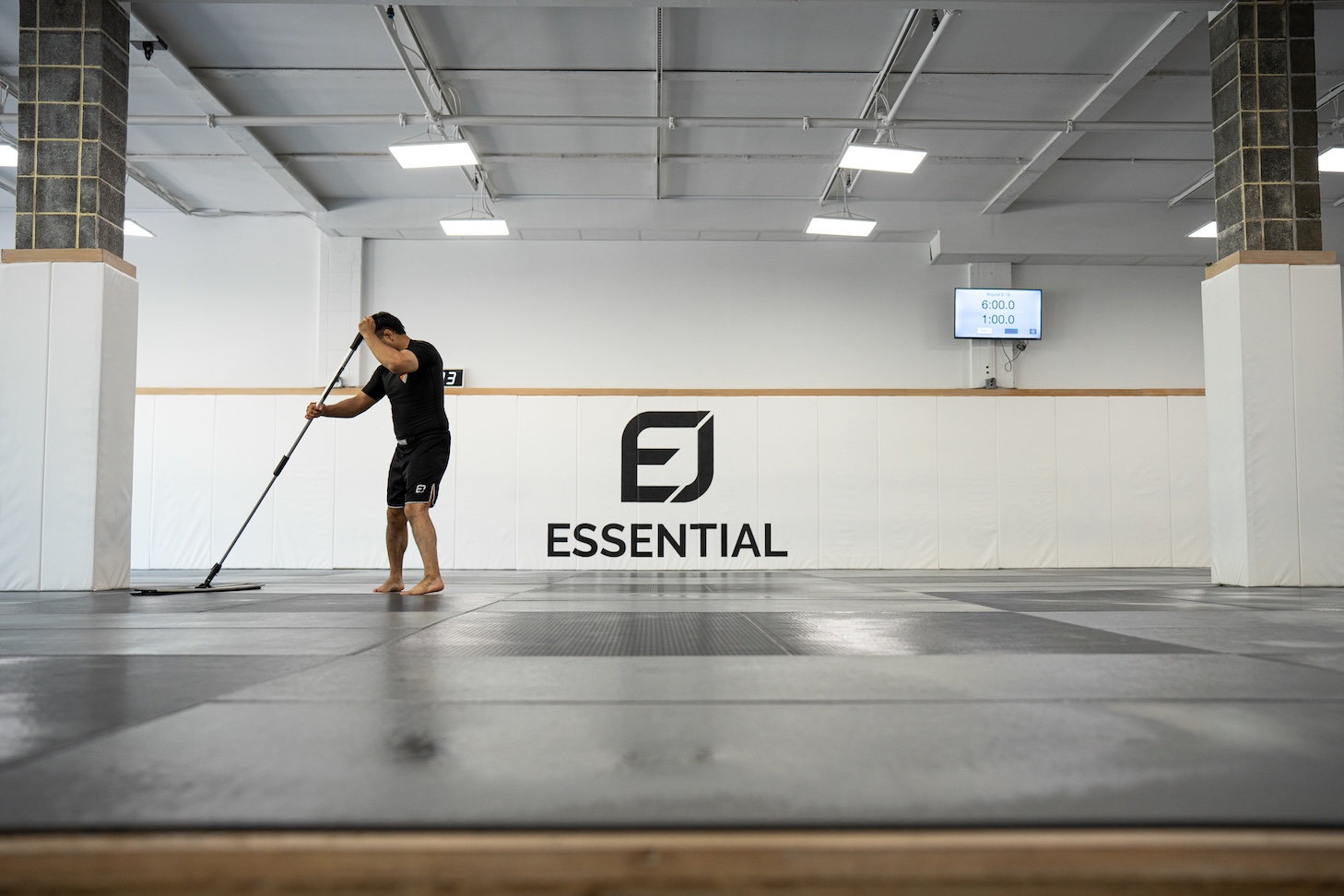 Brazilian Jiu Jitsu coach disinfecting training mats to help prevent staph, ringworm, and other skin infections